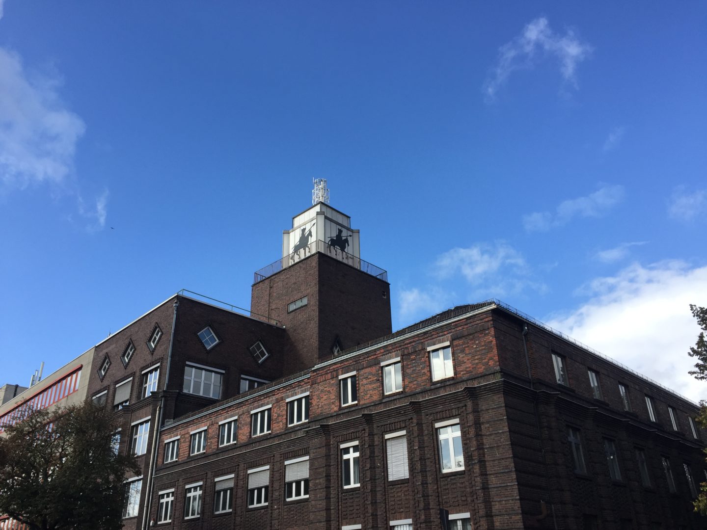 The Alboin Kontor, a large brick building with a tower. On the tower is the silhouette of Alboin, King of the Lombards, depicted on horseback holding a spear.