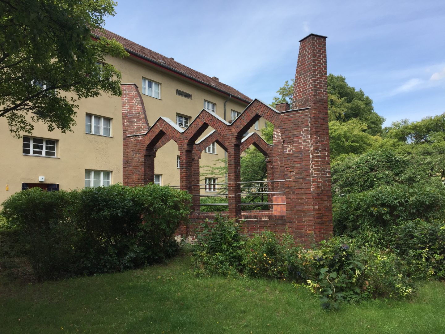 A brickwork fountain on a large triangular plinth.
